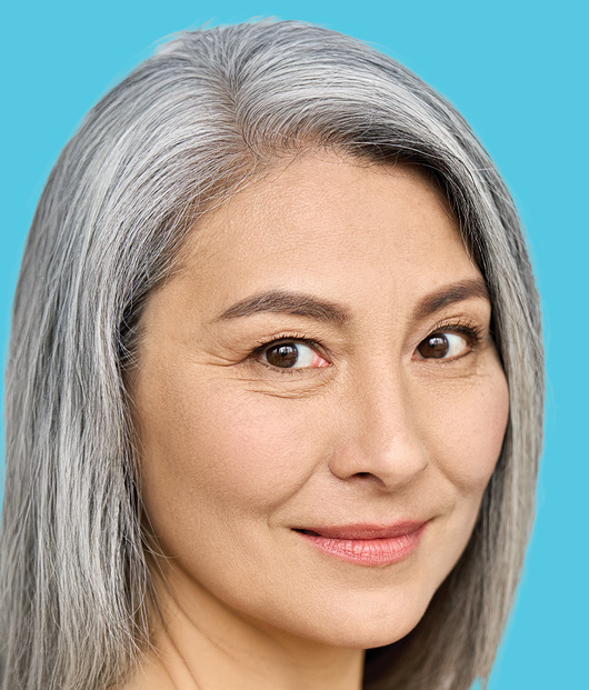 Close-up of woman's face in front of a light blue background. 