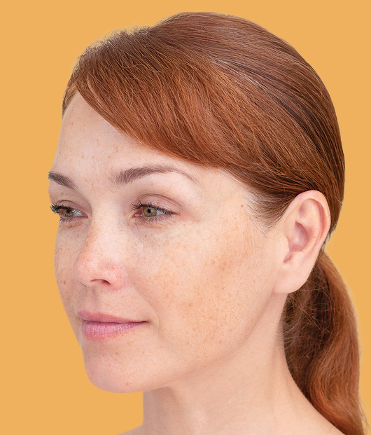 Close-up of woman staring off to the side in front of a light yellow background. 