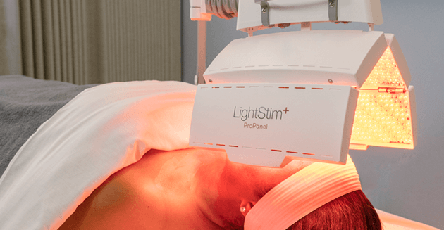 Woman receiving nourishing light treatment service at Massage Envy clinic. 