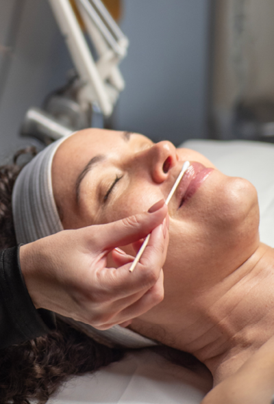 Woman receiving facial enhancement service at Massage envy clinic. 