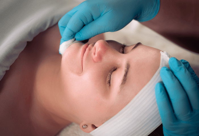 Woman with eyes closed smiling as she received facial at Massage Envy.