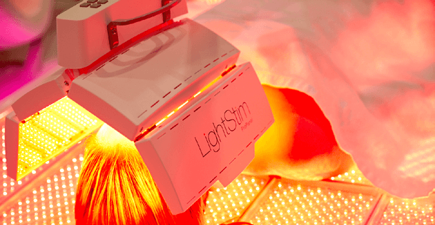 Close-up of woman receiving Full Body LED Light Therapy service at massage Envy. 