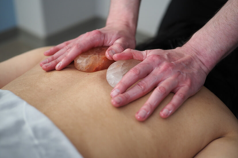 Close-up of customer's back as she receives Himalayan Salt Stone service at Massage Envy.  