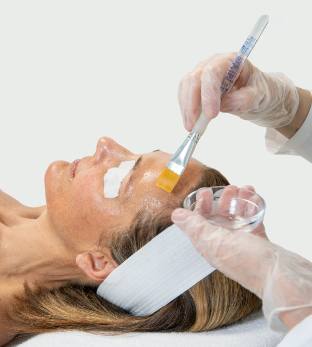 Woman receiving facial treatment from esthetician. 