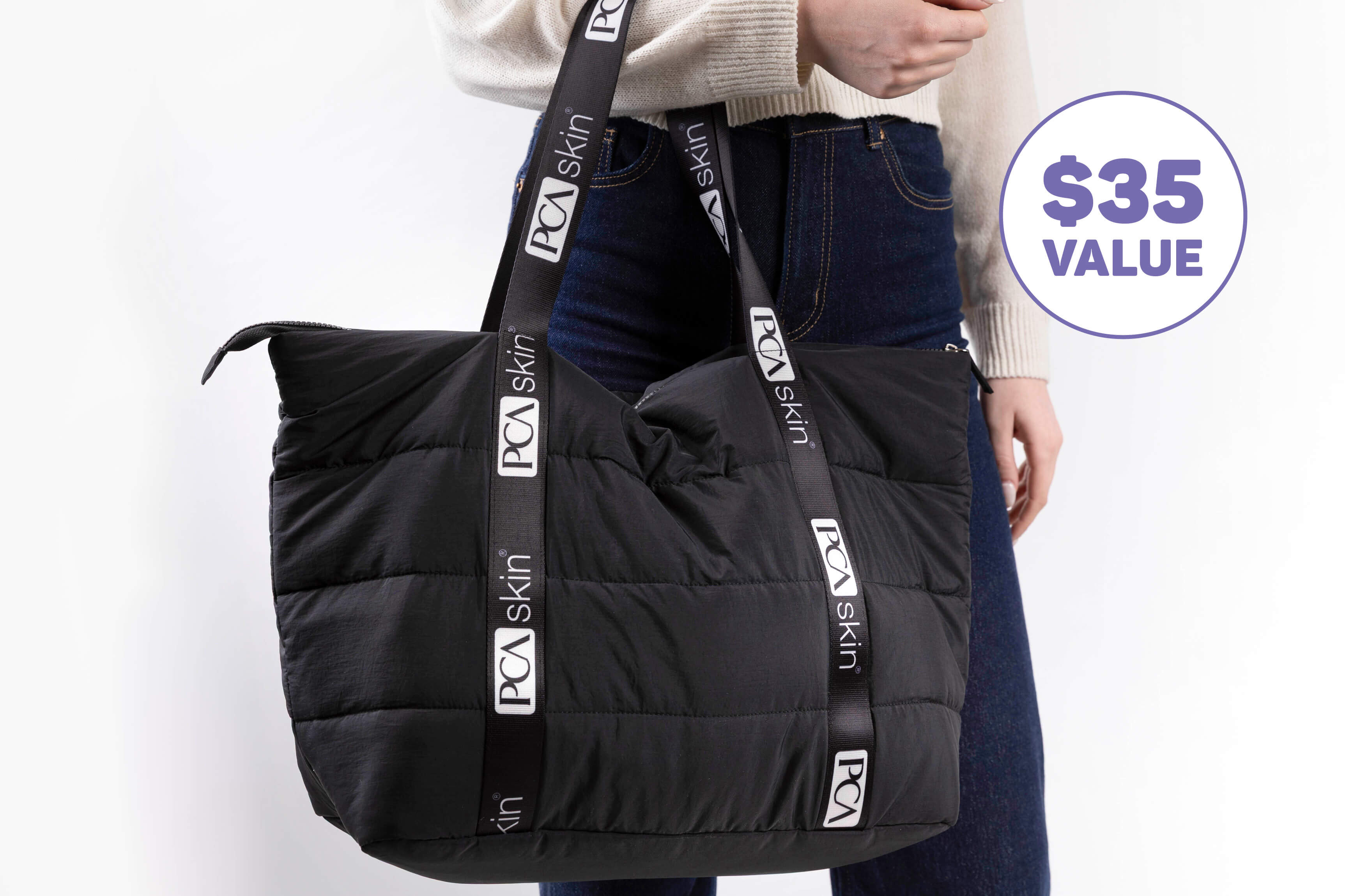 Close-up of woman holding a PCA Skin tote bag. $35 value. 